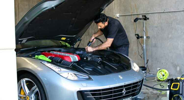 A mechanic is working on a ferrari car.